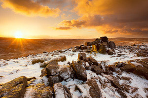 Golden sunrise over snow covered Belstone Tor, Dartmoor